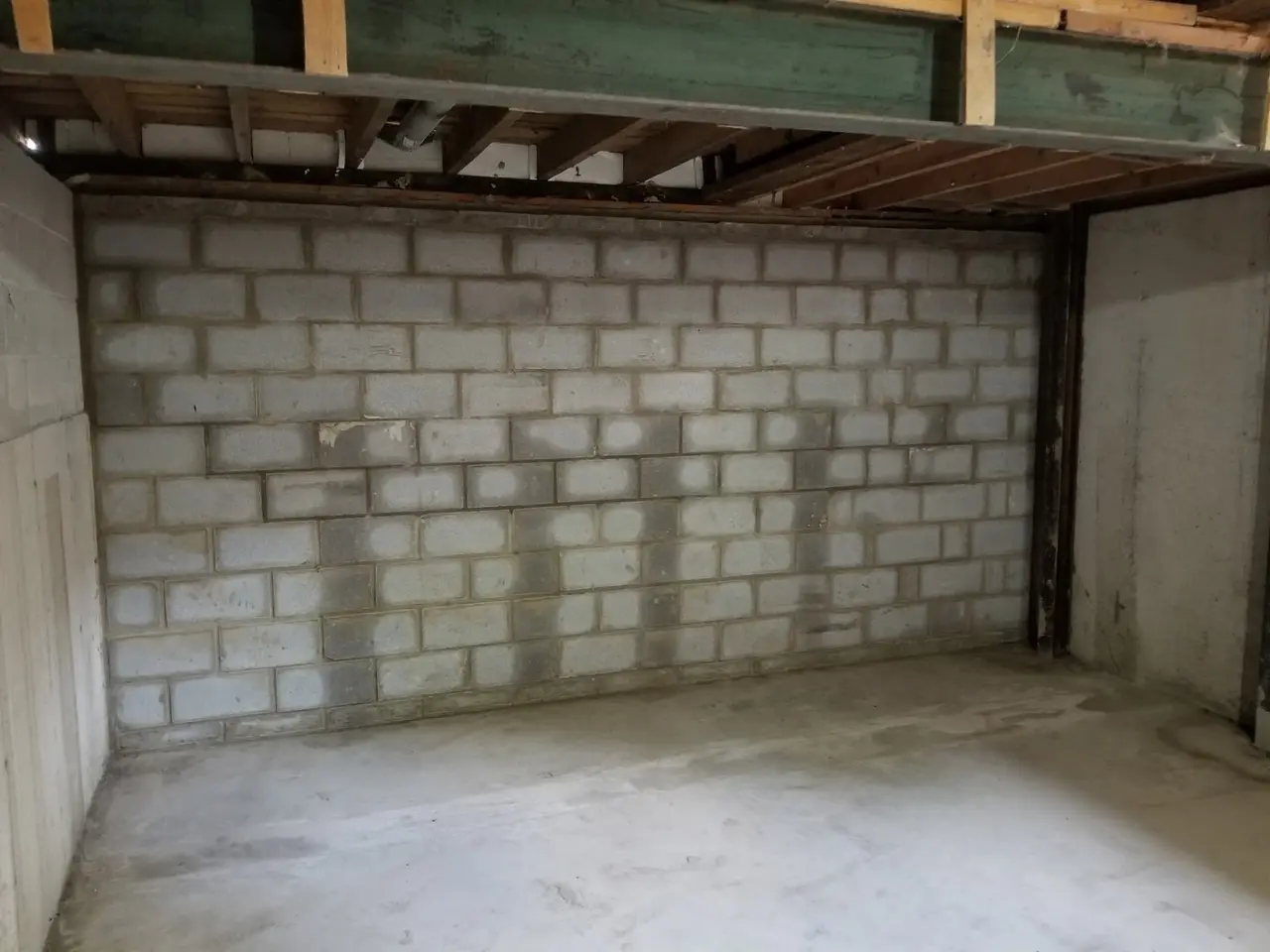 Basement with a new concrete floor slab poured against a clean block wall