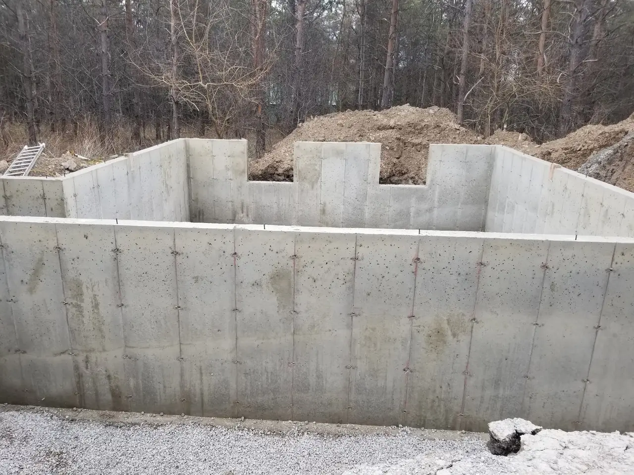 Freshly poured concrete foundation walls with form ties, ready for backfill