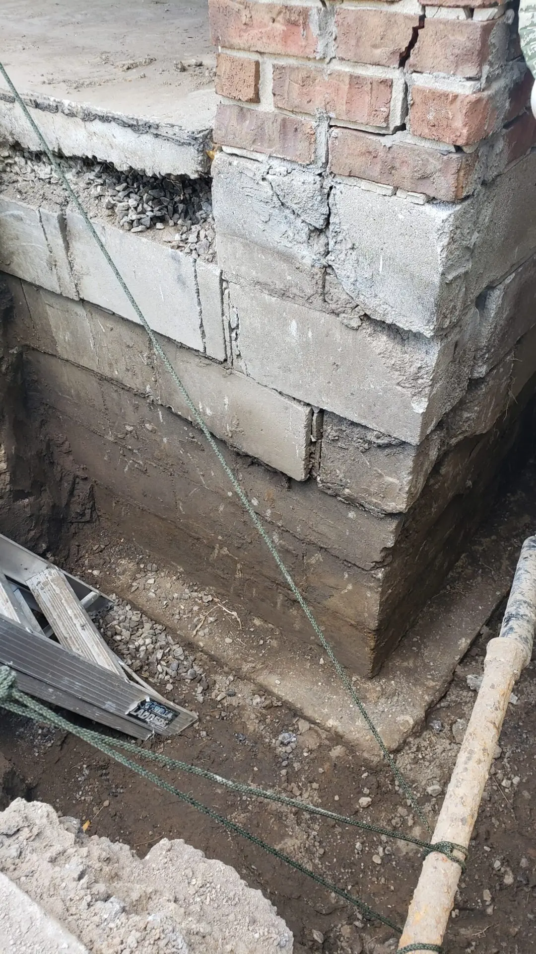Block foundation corner excavated for repair and waterproofing