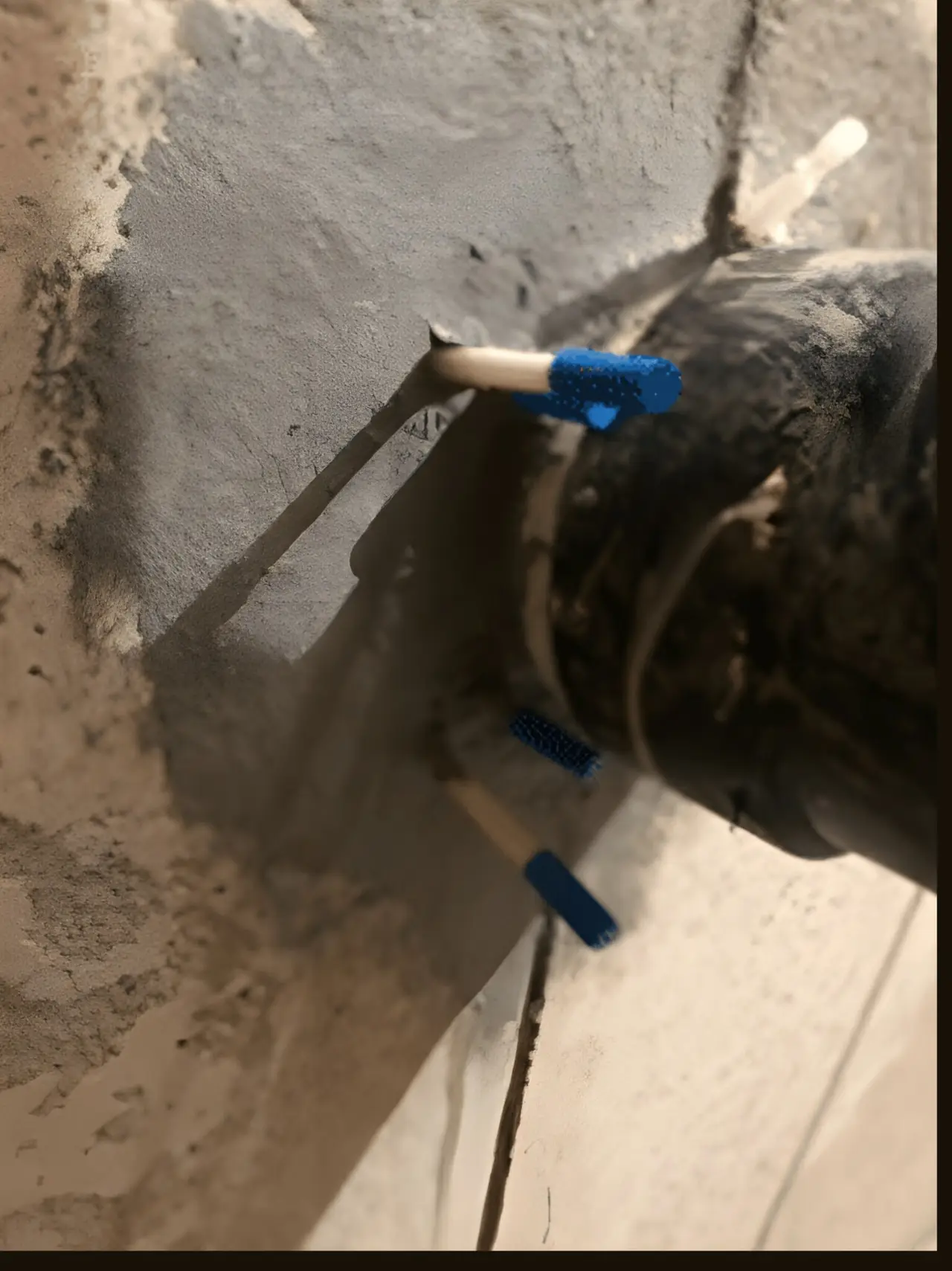 Injection port set into a poured concrete foundation crack, ready for polyurethane injection