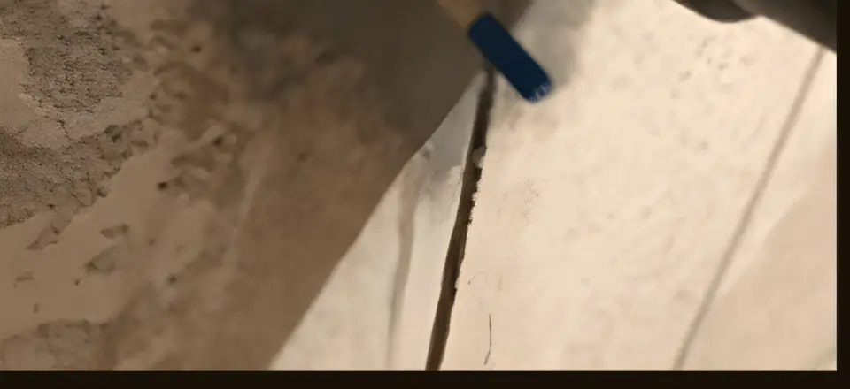 Injection port set into a poured concrete foundation crack, ready for polyurethane injection
