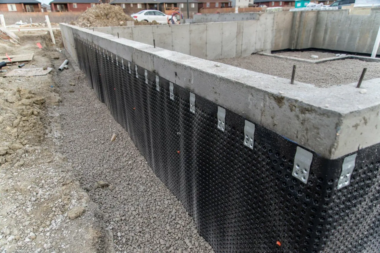 Dimpled drainage membrane and weeping tile on a new foundation wall, the exterior waterproofing system Basement Worx installs